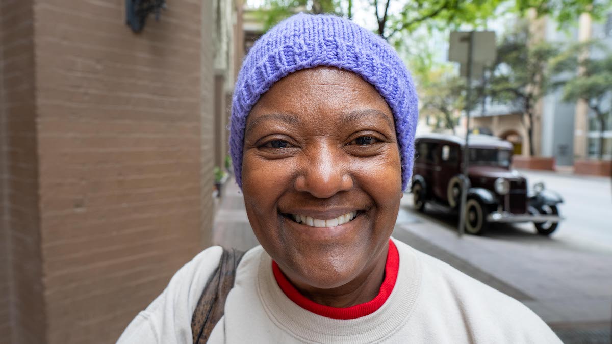 Smiling woman wearing a beanie outside.