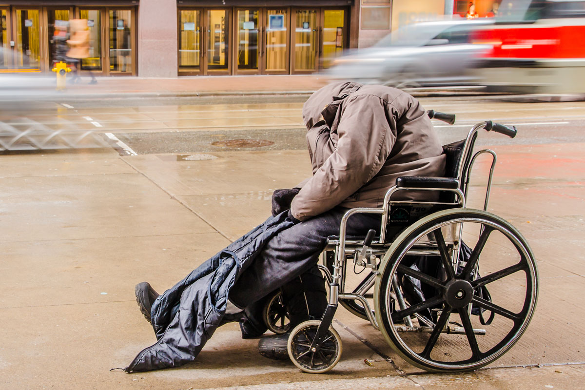 Disabled homeless person sleeps on the street
