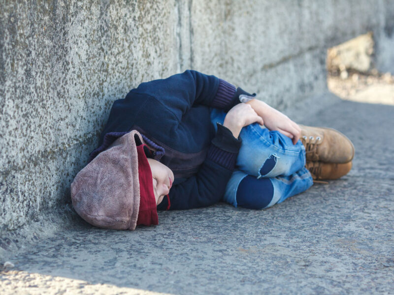 boy sleeping on concrete