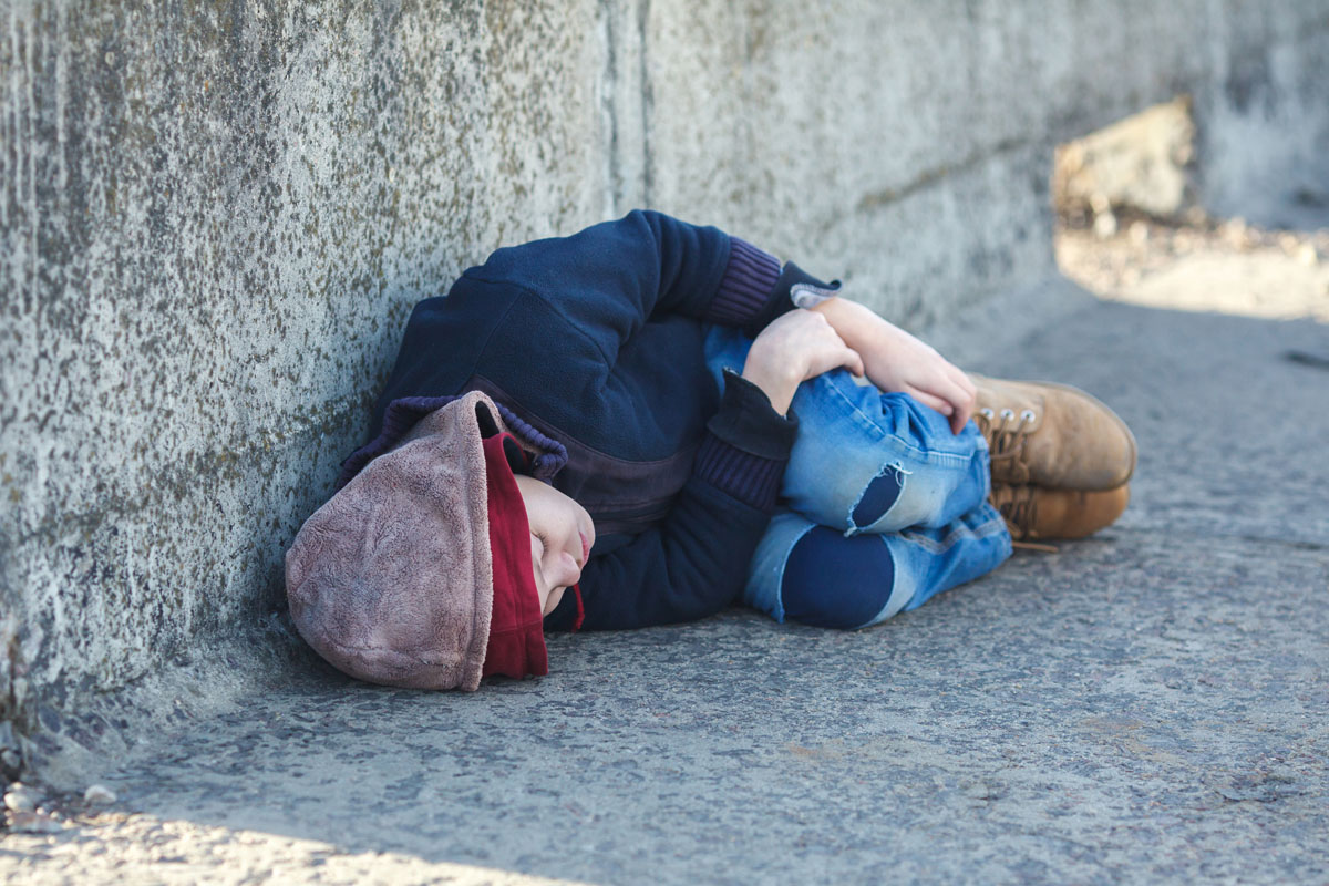 boy sleeping on concrete