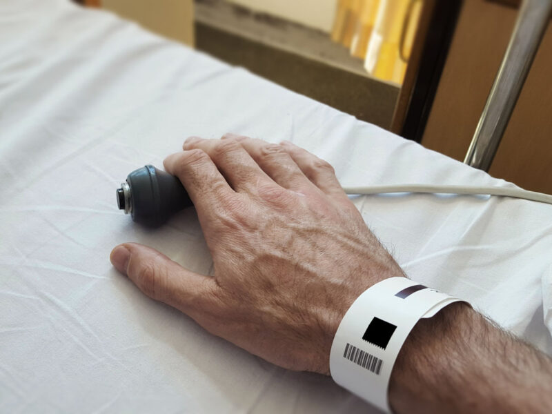 sick person's hand on nurse button