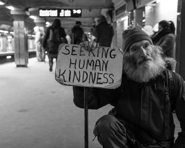 homeless man holding sign