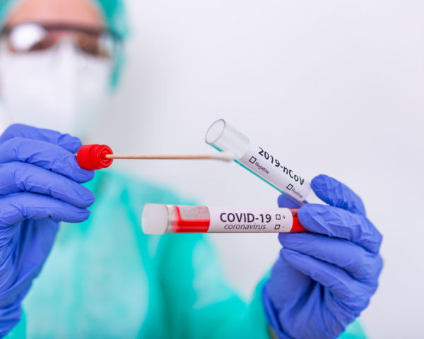 Nurse holding test tube and COVID-19 Nasal swab lab test