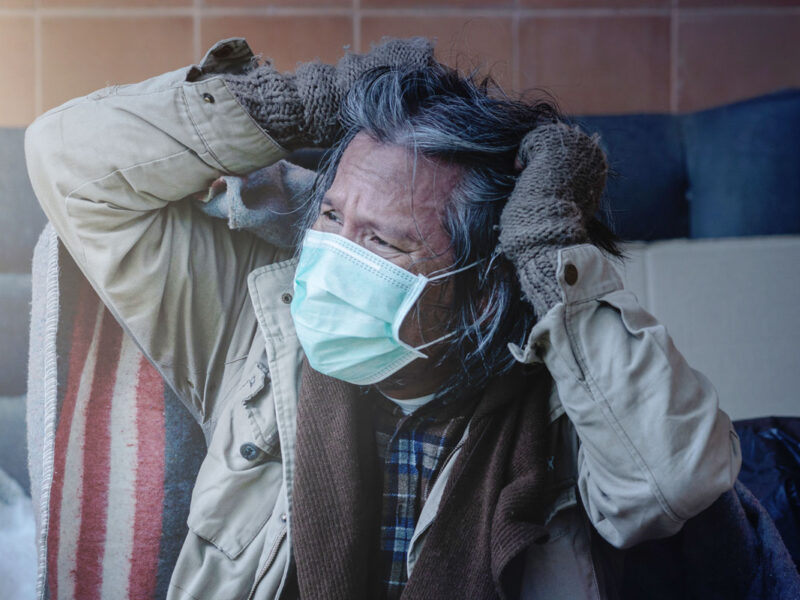 homeless man putting on a mask