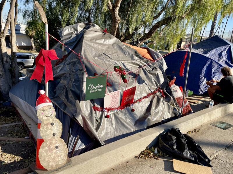 Christmas decorations on homeless person's tent
