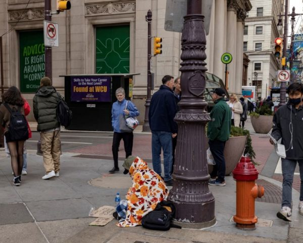 homeless person on a busy street corner
