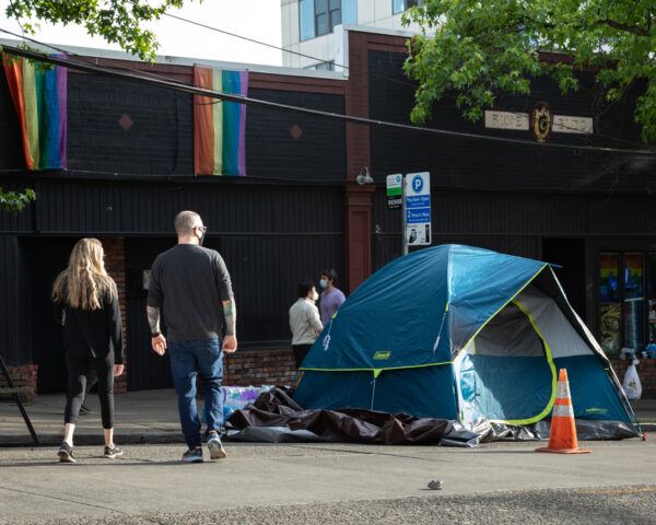 People walk by homeless tents in Seattle. The public doesn't believe housing first works