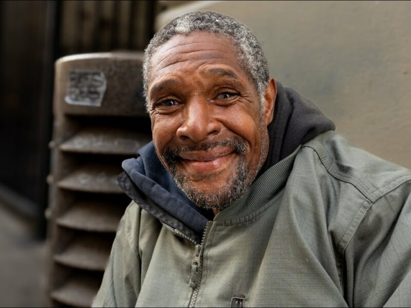 Homeless man sitting on sidewalk near Skid Row Los Angeles